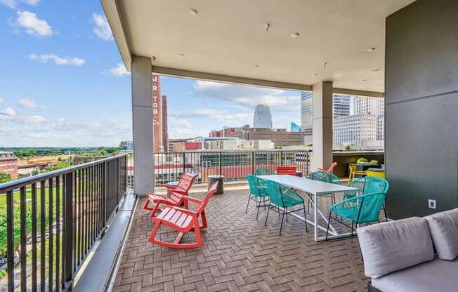 a balcony with a table and chairs and a view of the city at Link Apartments Innovation Quarter, Winston Salem, NC, 27101