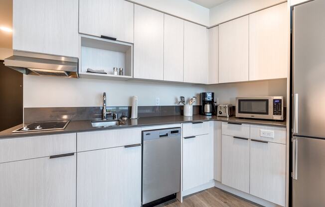 a kitchen with white cabinets and stainless steel appliances at Marina Square, Bremerton, WA
