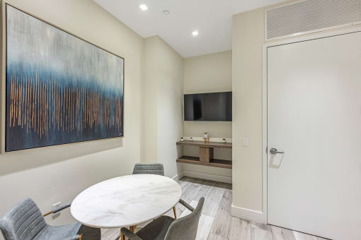 a dining room with a white table and chairs and a tv in a room