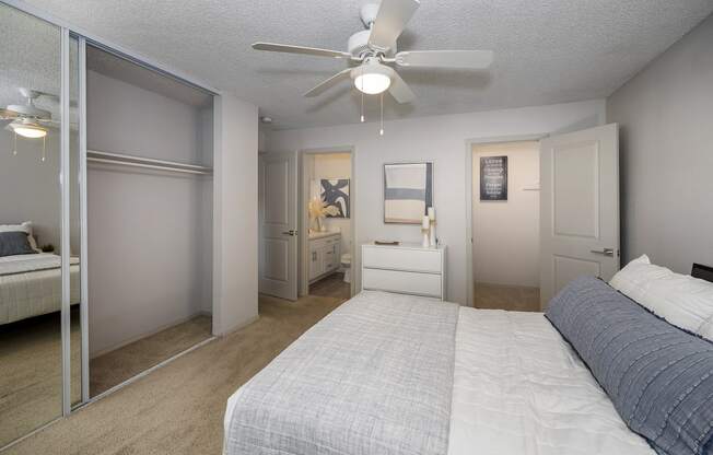 a bedroom with a bed and a ceiling fan