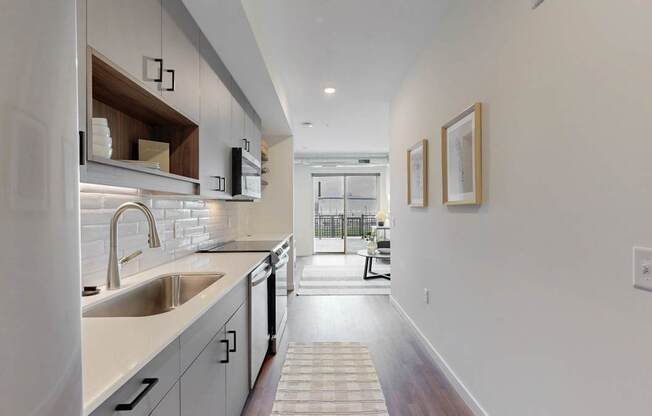 A modern kitchen with a white countertop and stainless steel appliances.