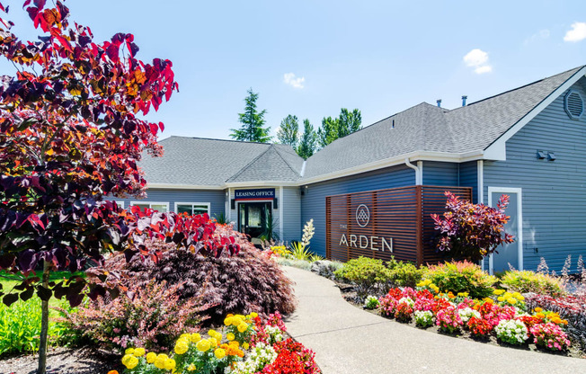 the front of the arden leasing office with a sidewalk and colorful flowers in front of it at The Arden Apartments, Gresham, 97080