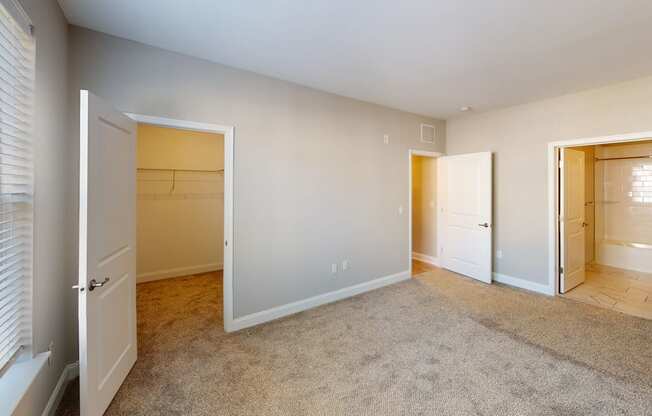 a bedroom with a closet and a door to a bathroom