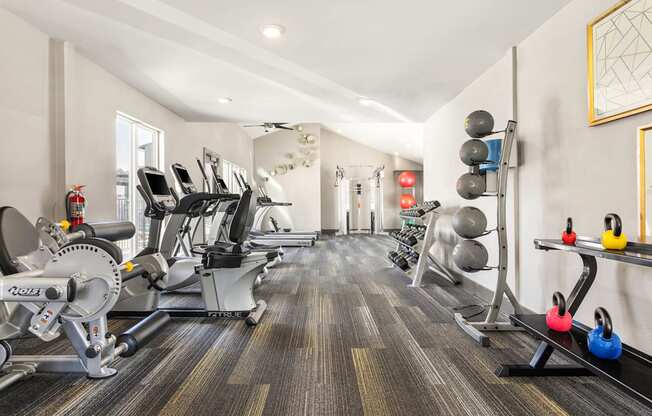 a gym with cardio machines and weights on the floor at South Lamar Village, Austin