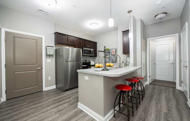 a kitchen with stainless steel appliances and a bar with stools