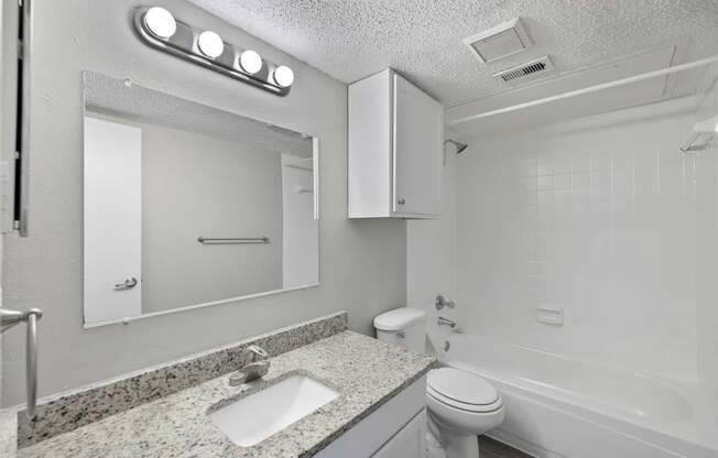 A white bathroom with a sink, toilet, and bathtub.