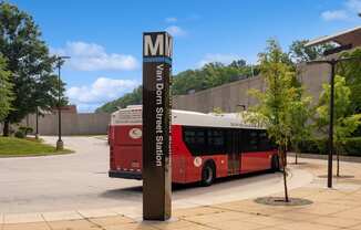 a red bus parked in front of a sign for the mg bus stop