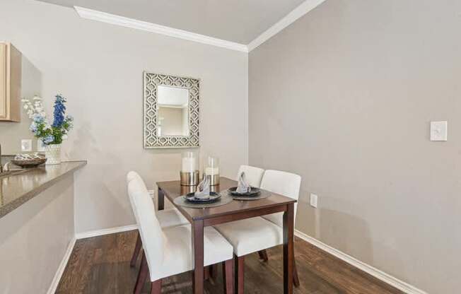 a dining room with a table and chairs and a mirror