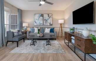Living room with large window, modern flooring and paint colors, and ceiling fan at Preserve at Cedar River Apartments, Florida