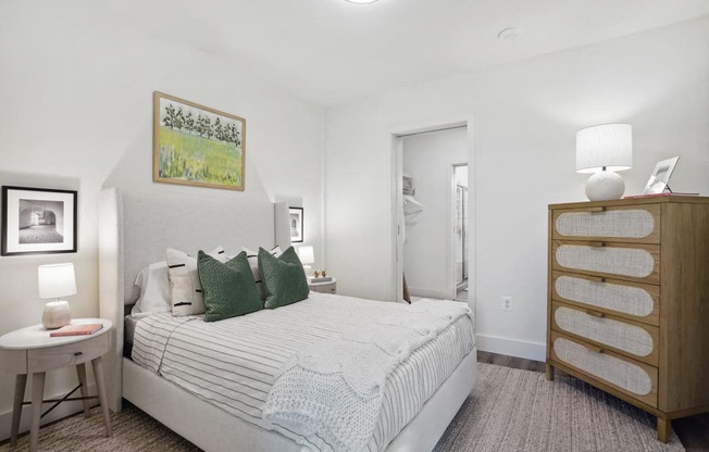 a bedroom with a bed and a dresser and a bathroom at Sinclaire on Seminary, Alexandria Virginia