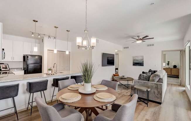 A modern dining room with a wooden table and grey chairs.