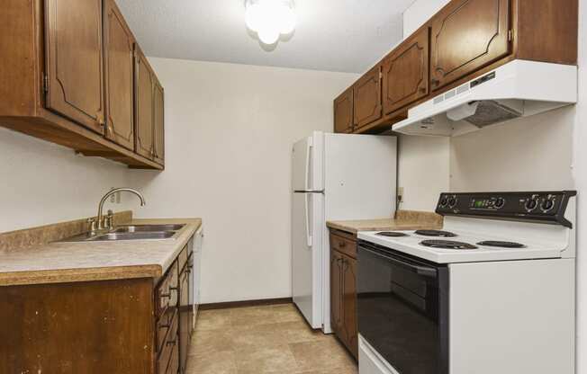 a kitchen with a stove refrigerator and sink. Fridley, MN Georgetown on the River Apartments