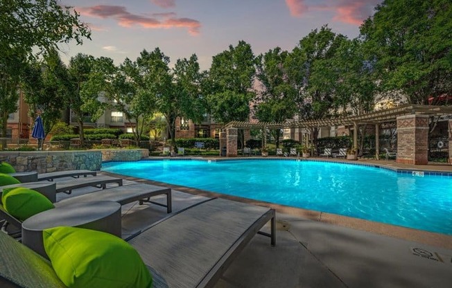 a swimming pool with chairs and tables next to it