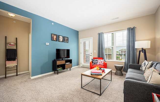 a living room with a blue wall and a couch and a table