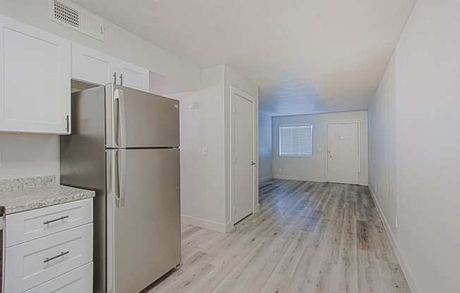 a kitchen with white cabinets and a stainless steel refrigerator