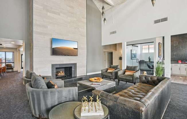A living room with a fireplace and a painting of a desert landscape on the wall.
