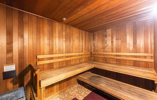 a wooden sauna with wooden benches and a chair