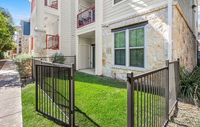 the front of a house with a yard and a fence