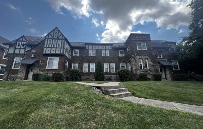 a large brick building with a cloudy sky in the background at Cincinnati Premier Living*, Cincinnati, Ohio