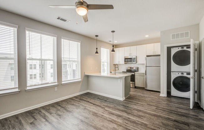 a kitchen and living room with a washer and dryer at Century University City, Charlotte, 28213