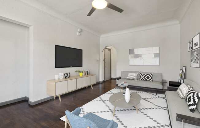 a living room with a ceiling fan and a tv on the wall at Del Mor Apartments, California