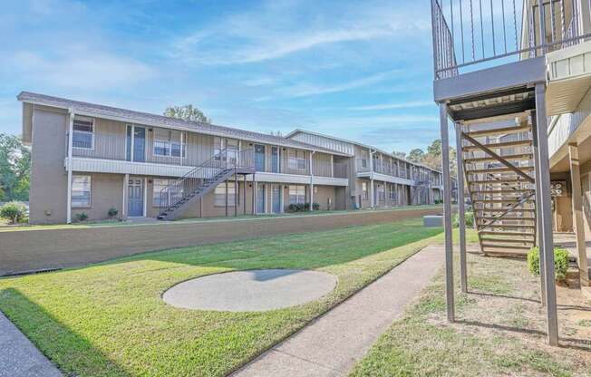 A view of apartment buildings with a metal staircase on the right at The Creole Apartments in Shreveport, LA