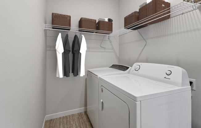 a white washer and dryer in a laundry room with a rack of clothes