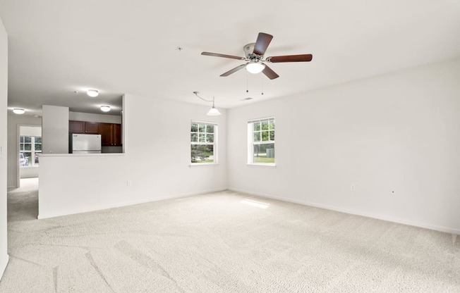 A room with a ceiling fan and carpeted floor.