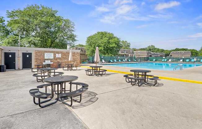 Picnic tables are arranged around a pool.