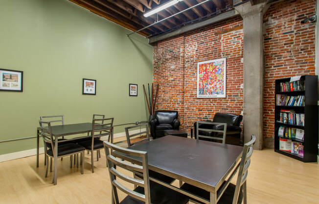 a dining room with a table and chairs and a brick wall