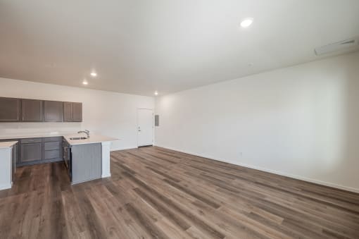 an empty living room and kitchen with wood floors and white walls at Gateway Apartments, East Wenatchee ,Washington, 98802