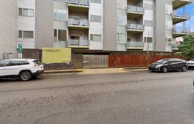 A white car is parked on the side of the road in front of a building.