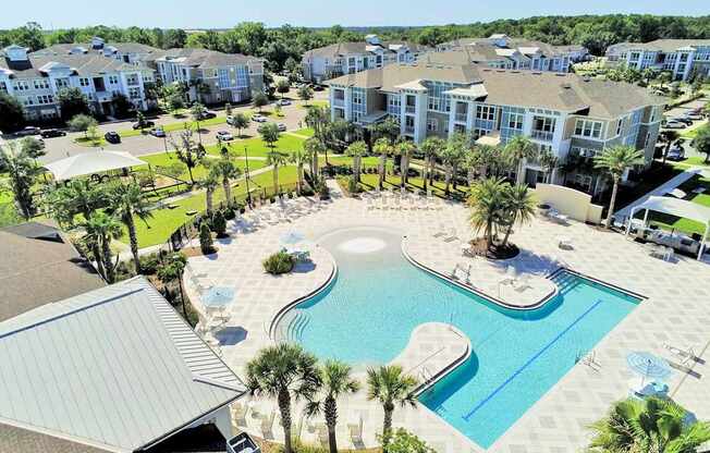 Beach-entry saltwater pool with splash pad, volleyball net, swim lane and cabanas