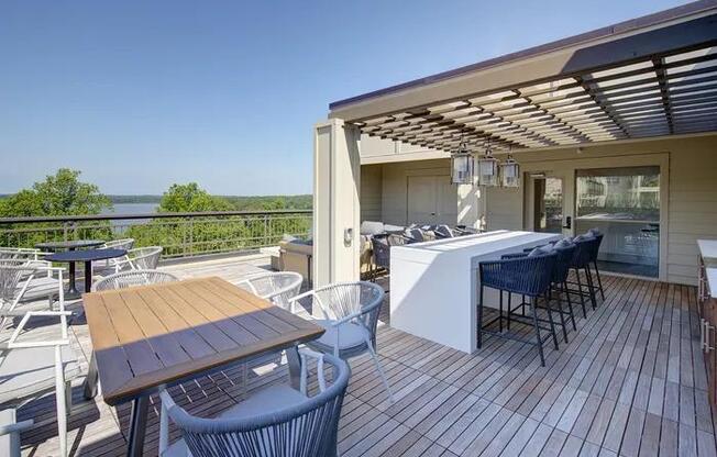 A wooden deck with a table and chairs overlooking a body of water.