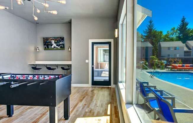 A room with a pool table and a foosball table.