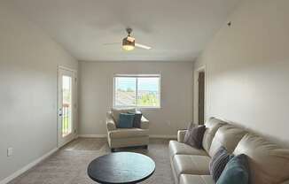 A living room with a beige couch and a round table.