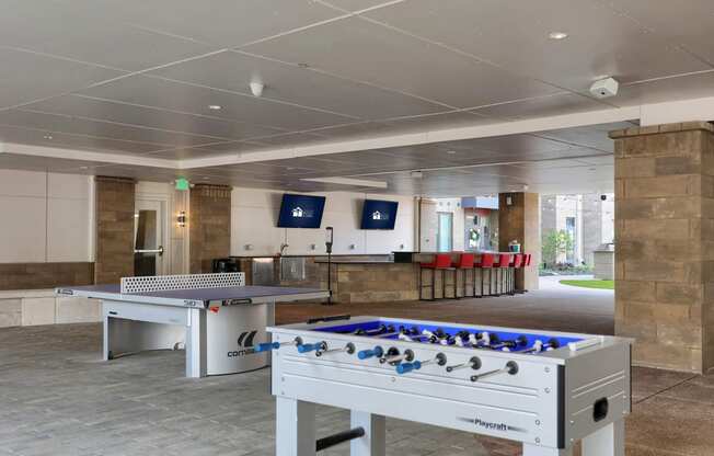 a games room with two foosball tables and a ping pong table