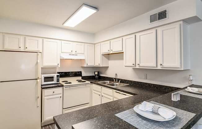 a kitchen with white appliances and granite counter tops