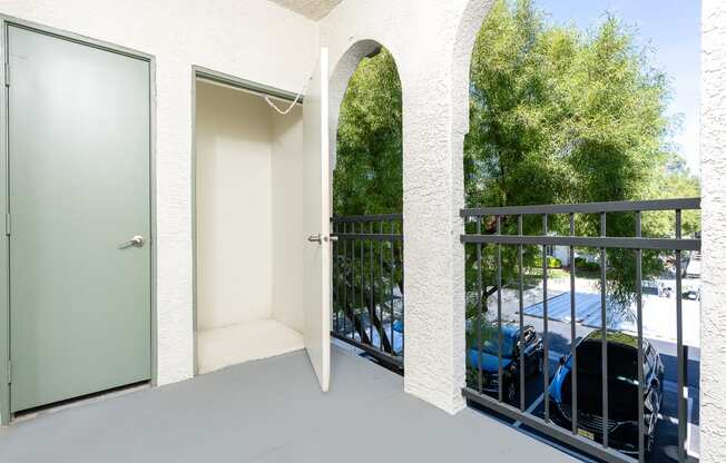 a balcony with a door to a parking lot