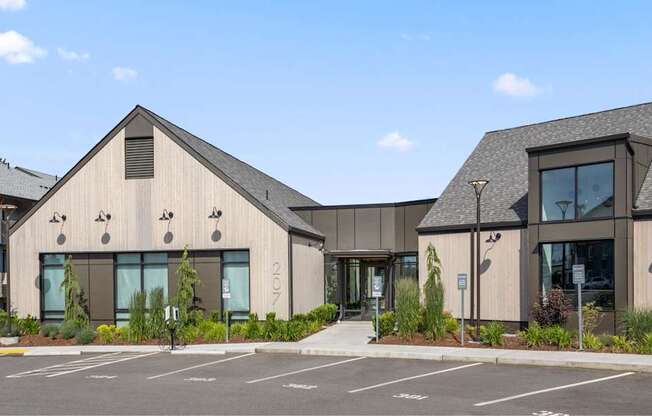 A modern building with a parking lot in front.