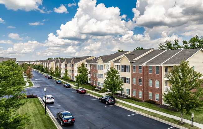 an aerial view of an apartment complex with cars parked on a street