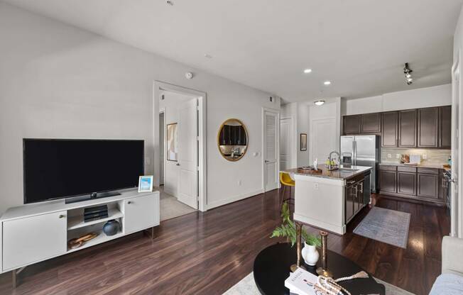 a living room and kitchen with a large tv