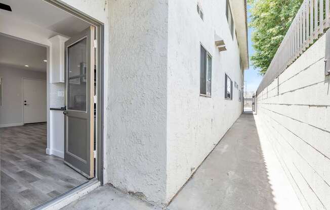 A white building with a grey door and a grey floor.