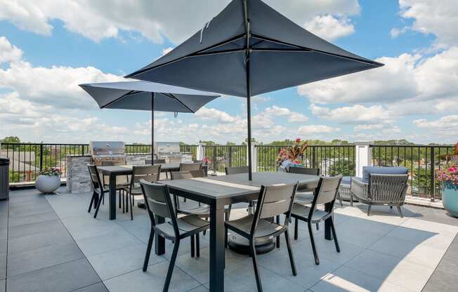 a patio with tables and chairs and umbrellas