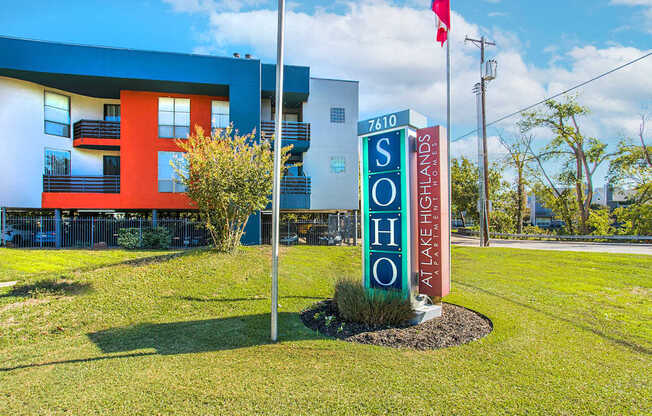 a sign in front of a motel with a building in the background