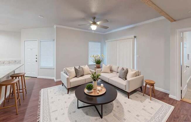 A living room with a white couch, a coffee table, and a ceiling fan.