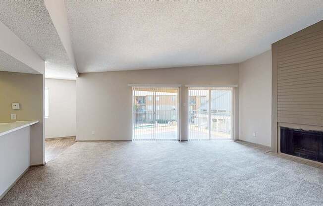 A spacious living room with a fireplace and sliding glass doors.