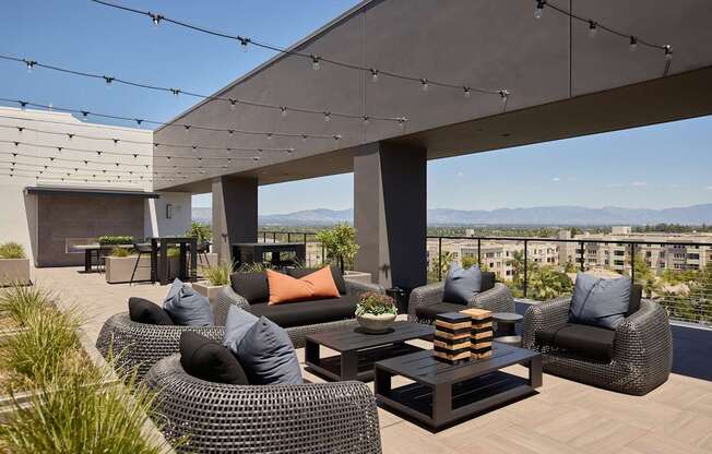 A modern outdoor patio with wicker furniture and string lights.