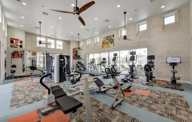 Fitness Center with Excercise Bikes, Ellipticals, Ceiling Fan and Patterned Rug at Morgan Ranch Apartments, California, 95037