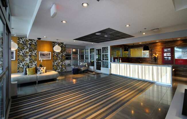 the lobby of a hotel with a bar and a striped floor